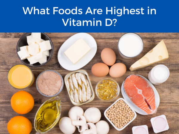 eggs, meat, mushrooms, oranges, cheeses, and grains on a table underneath the title"What Foods Are Highest in Vitamin D"