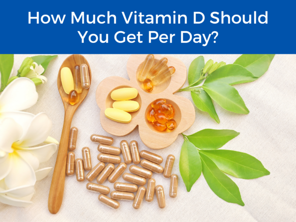 supplements and flowers under the title "How Much Vitamin D Should You Get Per Day?"