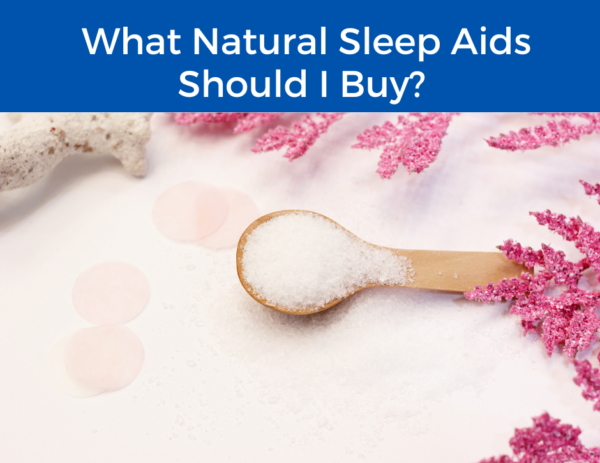 image of white supplement in a wooden spoon next to pink leaves under the title "What Natural Sleep Aids Should I Buy?" 